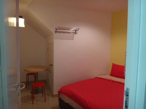 a bedroom with a bed and a table and stool at Famosa 2 Stay in Melaka