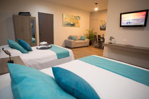 una camera d'albergo con due letti e un soggiorno di Suites and Art a Cancún