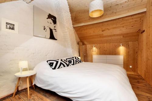 ein Schlafzimmer mit einem weißen Bett in einem Holzzimmer in der Unterkunft Vakantiewoning Martha in Veurne