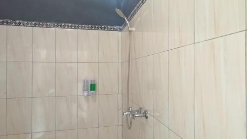 a bathroom with a shower with a shower head at Ginanthi Cottage in Nusa Penida