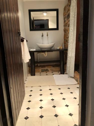 a bathroom with a sink and a mirror and a sink at Newstead Farm - Country Cottages in Curryʼs Post