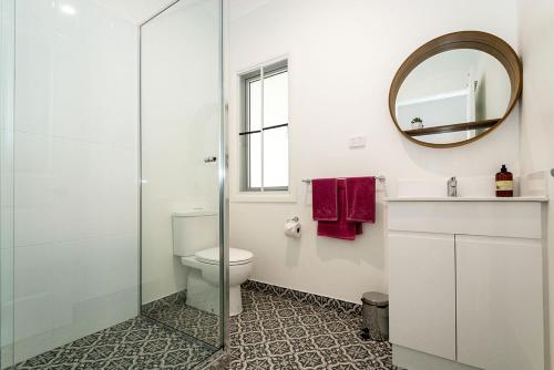 łazienka z toaletą i lustrem w obiekcie Island Cottages w mieście Nelly Bay