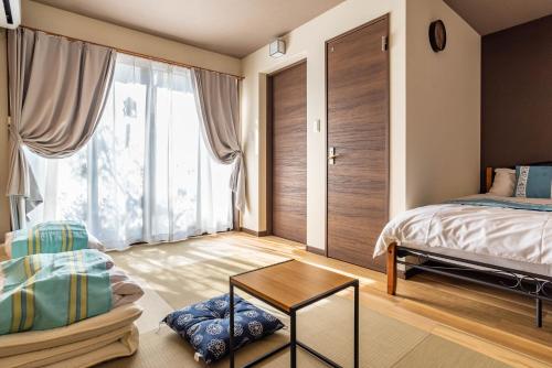 1 dormitorio con cama y ventana grande en Tino Asuka en Osaka