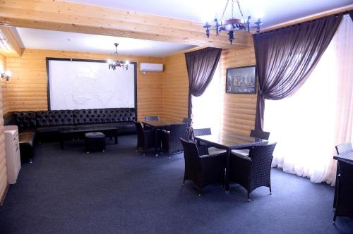 a room with a projection screen and tables and chairs at Pride Hotel in Taraz