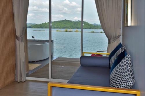 a boat with a view of a tub and the water at Raya Buri Resort Kanchanaburi in Si Sawat