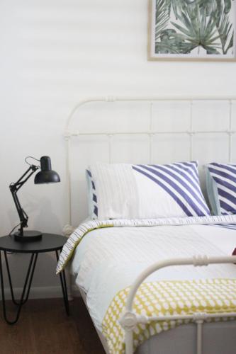 a bedroom with a bed with a lamp on a table at Island Cottages in Nelly Bay
