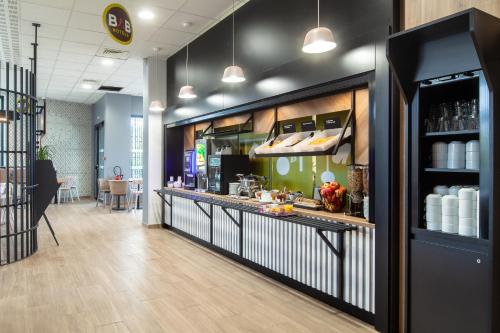 a bar in a restaurant with a counter at B&B HOTEL Paris Gennevilliers Asnières in Gennevilliers
