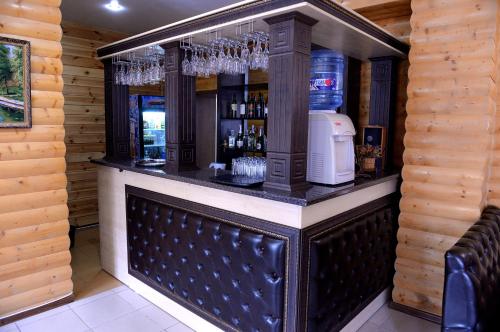 a bar in a log cabin with wine glasses at Pride Hotel in Taraz
