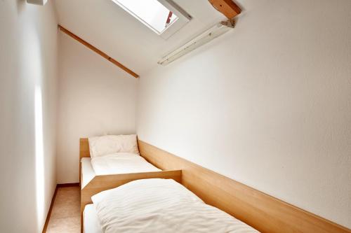 a small room with two beds and a window at Appartements am Stadtpark Zell am See in Zell am See