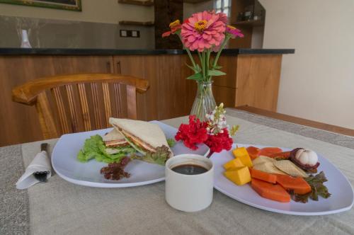 due piatti di cibo con un panino e un vaso di fiori di Liam Private Villa ad Ubud