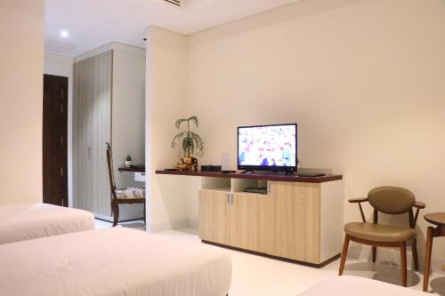 a bedroom with a tv on a wall at LCS Hotel & Apartment in Phnom Penh