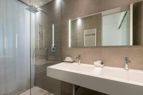 a bathroom with a white sink and a shower at Hotel Polo in Rimini