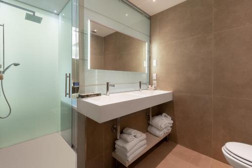 a bathroom with a sink and a mirror and a toilet at Hotel Polo in Rimini