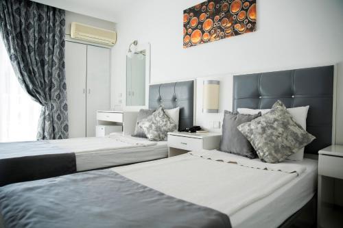 a bedroom with two beds and a window at Halıcı Hotel Marmaris in Marmaris