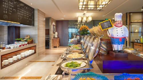 a buffet line with plates of food in a restaurant at SSAW Boutique Hotel Ningbo CBD in Ningbo