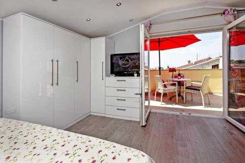 een slaapkamer met een bed en een tafel met een paraplu bij Apartments Babo in Rovinj