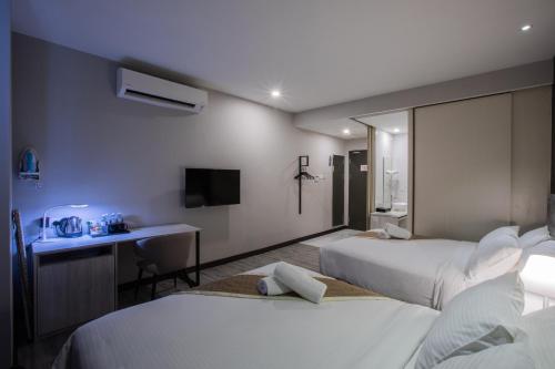 Habitación de hotel con 2 camas y escritorio en The Leverage Business hotel (Skudai) en Johor Bahru