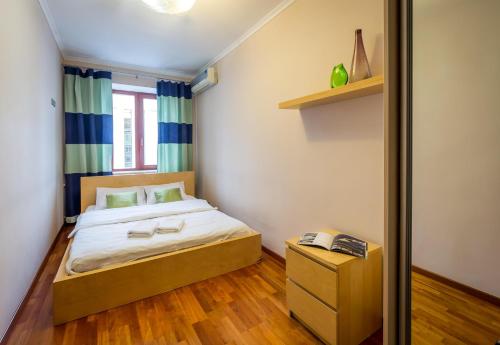 a small bedroom with a bed and a wooden floor at DayFlat Apartments Maidan Area in Kyiv