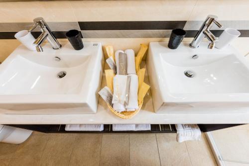 two white sinks in a bathroom with towels at ManMan House Ruifang in Ruifang