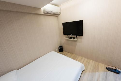 a bedroom with a bed and a flat screen tv at ManMan House Ruifang in Ruifang