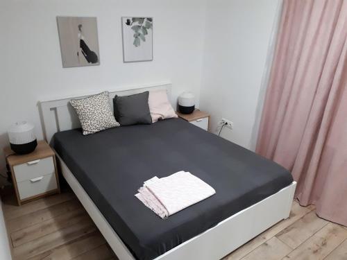 ペーチにあるLuxury City Central Wellness Apartmanのピンクのカーテンが備わる白い部屋のベッド1台