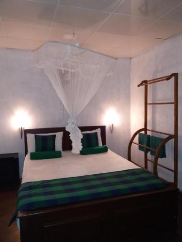 a bedroom with a bed with green and white pillows at Ella green stay in Ella