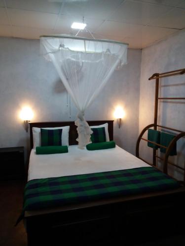 a bedroom with a bed with green and white pillows at Ella green stay in Ella