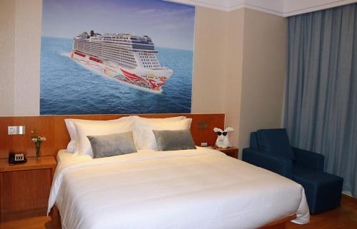 a bedroom with a large bed and a cruise ship painting at Linjiang International Cruise Hotel Baoyang Road in Baoshan