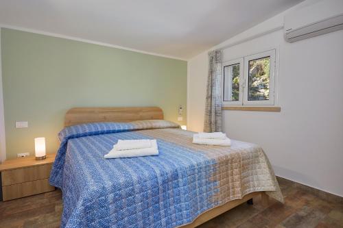 Un dormitorio con una cama con dos toallas encima. en Villa Montemar, en Balata di Baida