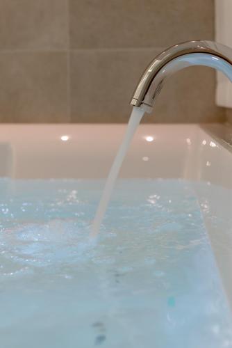 a bath tub with water coming out of a faucet at Hotel Polo in Rimini
