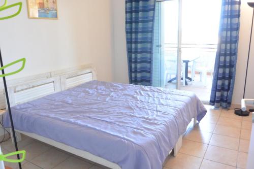 une chambre avec un lit avec une couette bleue dans l'établissement PALMERAIE 325, à Sari-Solenzara