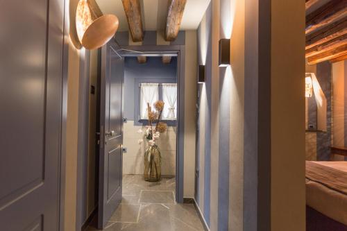 a hallway with a blue door and a vase of flowers at Hotel Tiziano in Venice