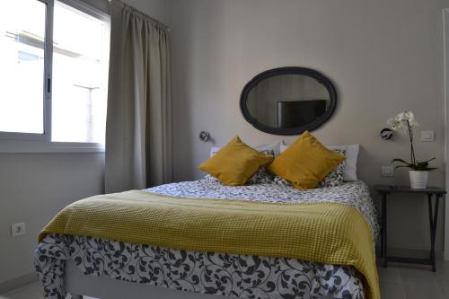 サンタクルス・デ・テネリフェにあるGFS Loftのベッドルーム1室(黄色い枕と鏡付きのベッド1台付)