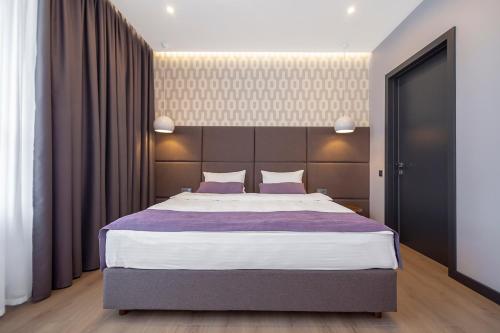 クロプィウヌィーツィクィイにあるApartUA Кропивницькийのベッドルーム1室(紫のシーツが敷かれた大型ベッド1台付)