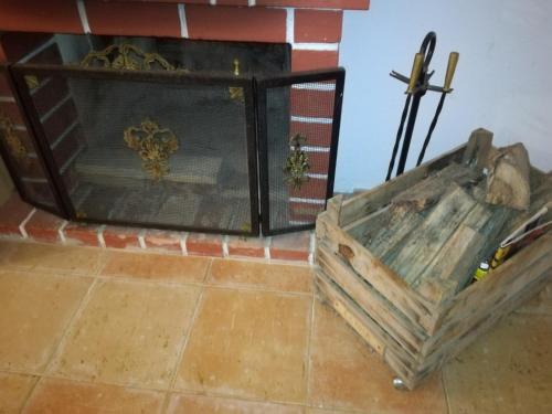a wooden box sitting on a floor next to a fireplace at Pro Touristic Montejunto Villas in Arieiro