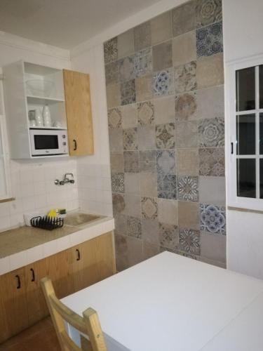 a kitchen with a table and a microwave at Pro Touristic Montejunto Villas in Arieiro