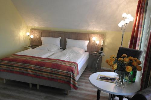 a hotel room with a bed and a table with a table sidx sidx at Landhaus Hammoor Stieper Gastronomie GmbH in Hammoor