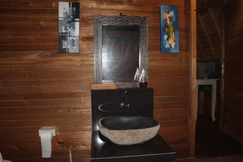 a bathroom with a large bowl sink and a mirror at Halumba Eco Villa Bali in Tejakula