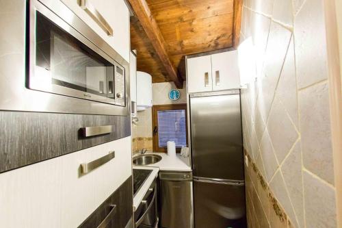 een keuken met een roestvrijstalen koelkast en een spoelbak bij Casa Torre Mudéjar in Toledo