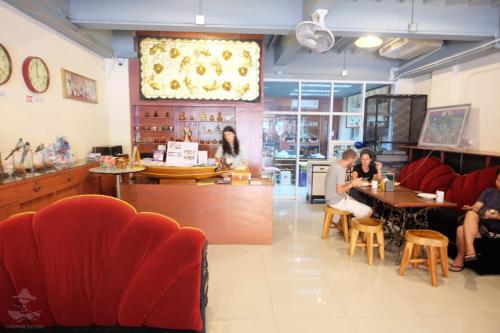 a restaurant with red chairs and people sitting at tables at Khaosan Station in Bangkok