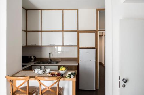 a kitchen with white cabinets and a table and chairs at Agora Apartments in Sorrento