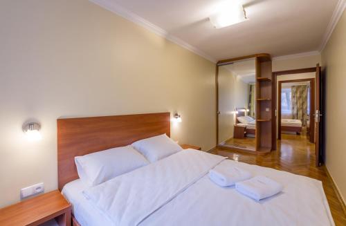a bedroom with a large white bed with two towels on it at Cheap Apartments in Kyiv