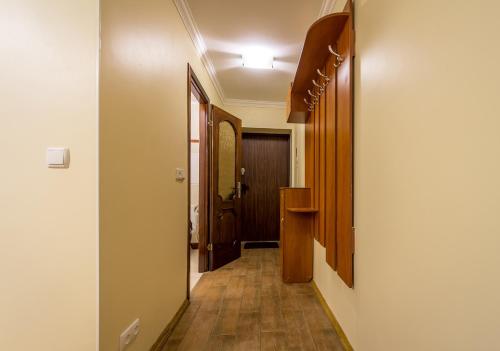 a corridor of a hallway with wooden floors and a door at Cheap Apartments in Kyiv