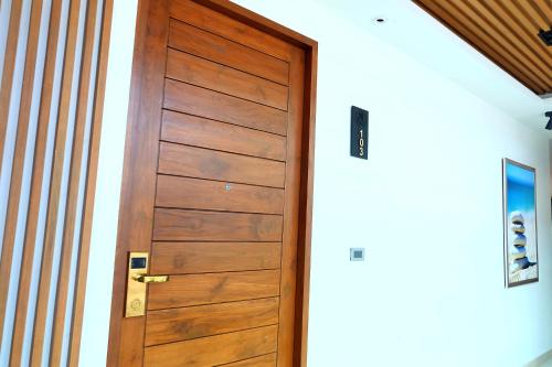 a wooden door in a room with a wall at Montana Hotel Songkhla in Songkhla