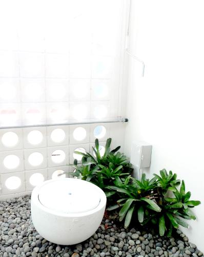 a bathroom with a toilet and plants in a room at Montana Hotel Songkhla in Songkhla