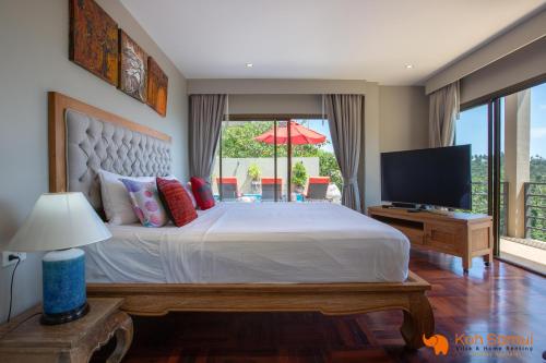 een slaapkamer met een groot bed en een televisie bij Villa Macha in Chaweng Beach