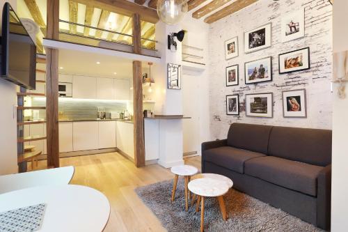 un salon avec un canapé et une cuisine dans l'établissement Résidence Le Marais by Studio prestige, à Paris