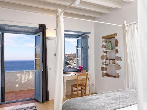 a bedroom with a desk and a view of the ocean at Patmos Eye Traditional Luxury Villas in Skala
