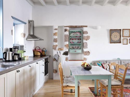 cocina con mesa y sillas en una habitación en Patmos Eye Traditional Luxury Villas, en Skala