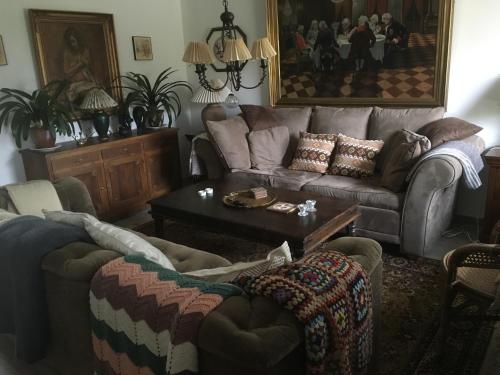 sala de estar con sofá y mesa en Ellekær-Gård, en Dronninglund